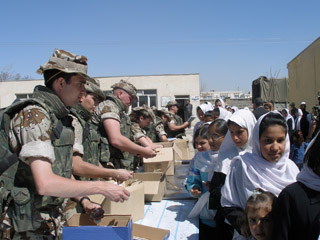 Soldados españoles repartiendo ayuda humanitaria a la población.