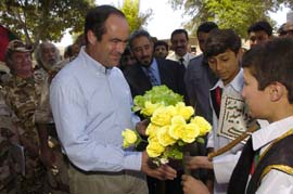 José Bono, ministro de Defensa recibe un ramo de flores a su llegada a Afganistán
