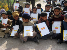 Niños de la escuela de Arja y Bagh en la Cachemira Paquistani, muestan las carpetas con material escolar, enviadas desde el ministerio de Defensa de España