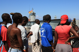 Haitianos observan el desembarco de vehículos y material español