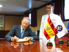 El ministro de Defensa, Pedro Morenés, firma en el libro de honor del buque Cantabria, surto en aguas de Melbourne (Australia), en presencia del comandante del barco, CN José Luis Nieto.