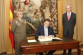 El presidente Mariano Rajoy firma el libro de honor en presencia del ministro Pedro Morenés y del director del CESEDEN , teniente general Alfonso de la Rosa.