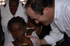 José Bono, junto a una niña, tras la entrega de juguetes en  Haití