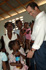 El ministro de Defensa, José Bono, rodeado de niñas  que acompañadas de sus madres,esperan para recibir un regalo de manos del ministro, durante su visita a Haití