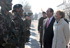 La vicepresidenta primera del Gobierno y el ministro de Defensa, saludan a soldados con la cara pintada de camuflaje.