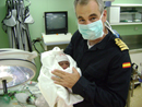 El comandante Francisco Peñuelas con el primer bebé nacido en el buque 'Castilla'