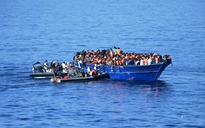 A speed boat form the Canarias frigate approaches the migrants' vessel
