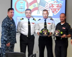 U.S. Navy personnel give two helmets to CASI instructors