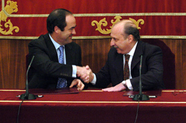 Los ministros de Defensa de España y Argentina se dan la mano tras la firma del convenio