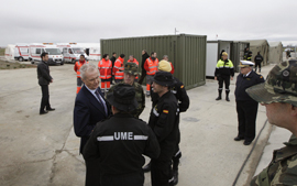 El ministro, durante su visita al campamento de damnificados, atendiendo a las explicaciones del coronel jefe del RAIEM