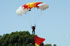 Un miembro de la Patrulla Acrobática Paracaidista del Ejército del Aire desciende con la Enseña Nacional