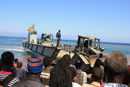 Haitianos observan el desembarco de vehículos y material español