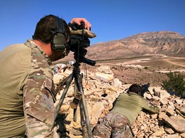 One of the students measures distance while another gets ready to shoot
