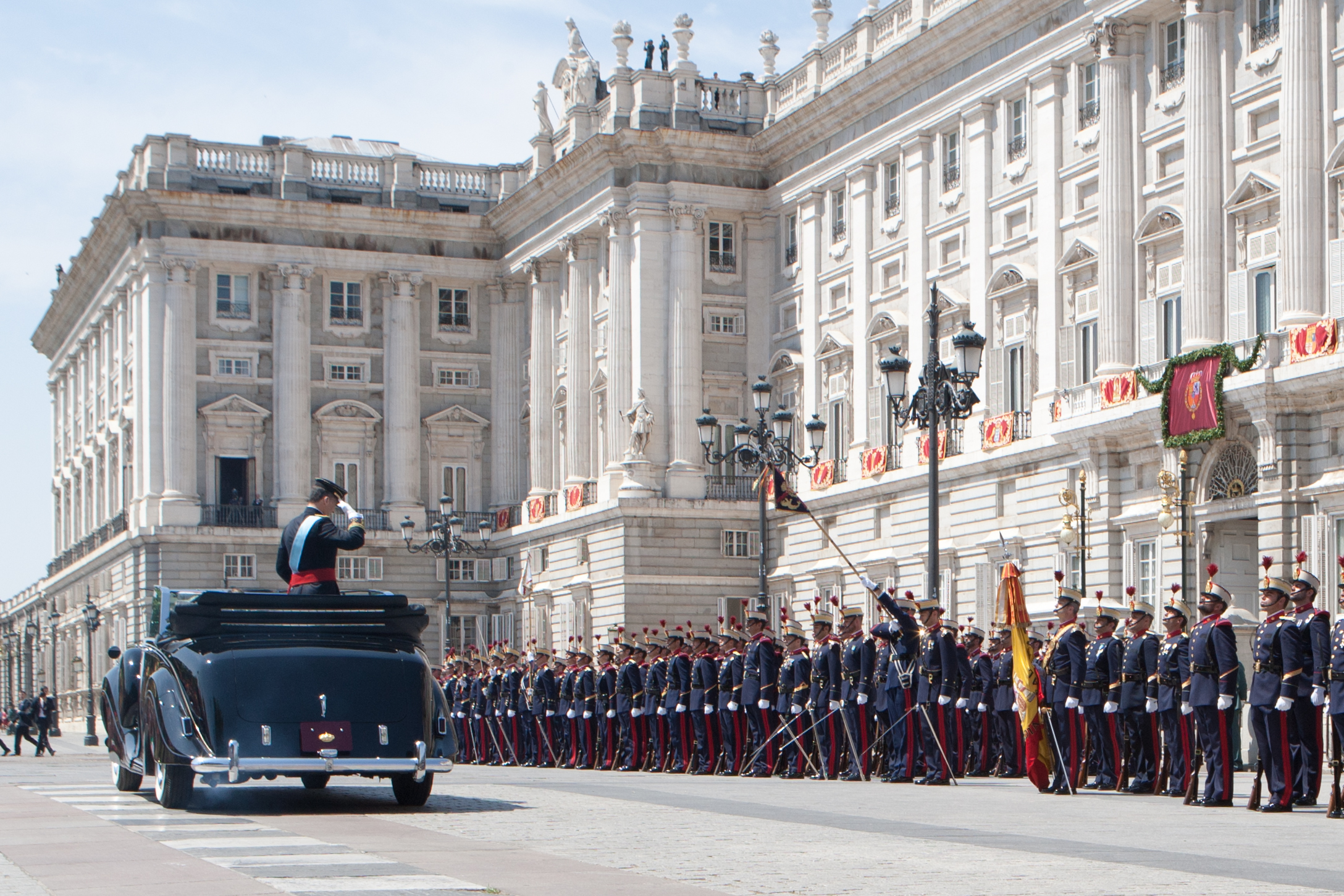 S. M. el Rey Felipe salundando a la Bandera Nacional a su llegada a Palacio Real 