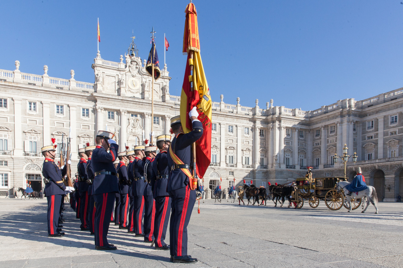 Una agrupación de honores de la Guardia Real rinde honores a un embajador que se dirige a palacio