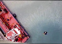 Maniobra de descenso de rescatadores y equipos del GIETMA desde el helicóptero al petrolero en el que se ha simulado un incendio.